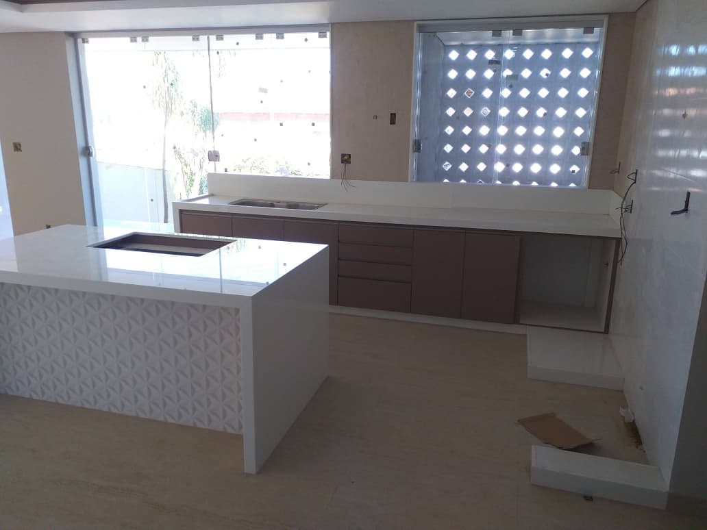 Cozinha finalizada com bancadas claras e ilha
