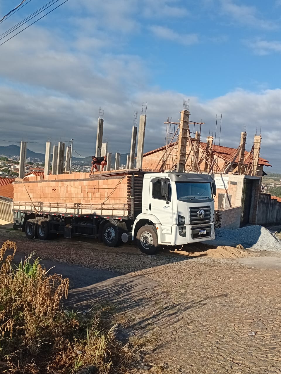 Estrutura residencial em execução com materiais entregues na obra