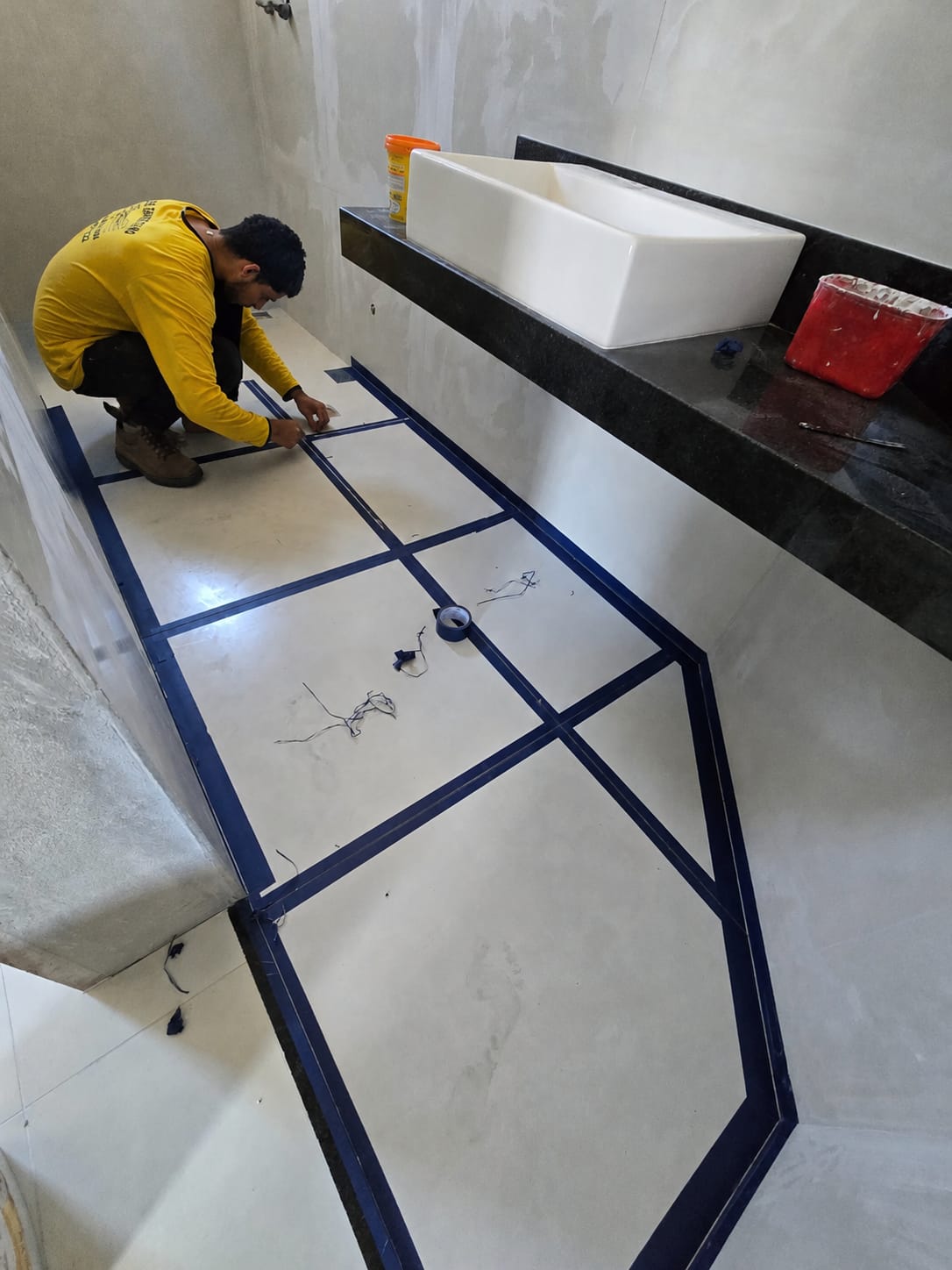 Profissional executando paginação decorativa no piso de banheiro